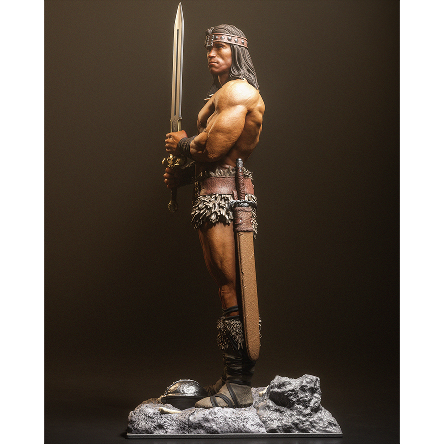 Resin figure of Conan the Barbarian holding a sword upright on a rocky base